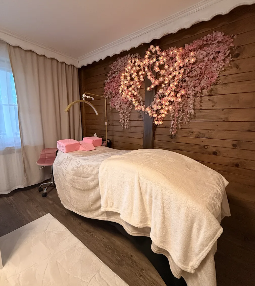 Behandlungsraum von Holly's Beauty in Erlbach mit Wimpernliege und Blütendekoration
